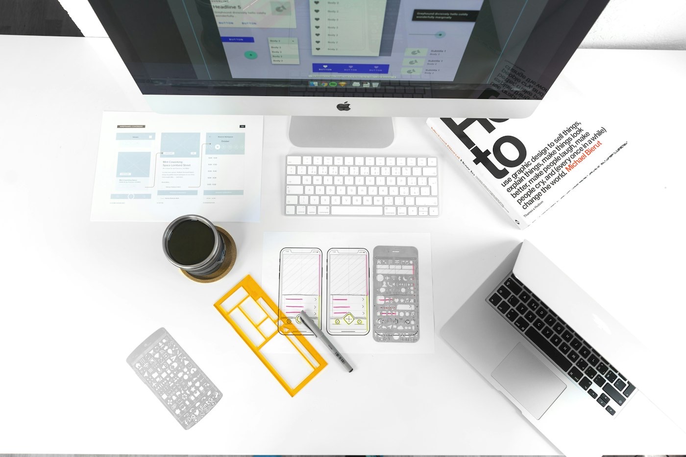 Table de travail de graphiste : livre de design, maquettes et gabarits d'interface