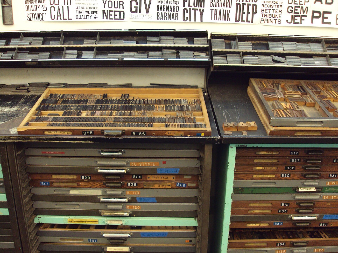 Casse typographique avec tiroirs de caractères et affiches imprimées